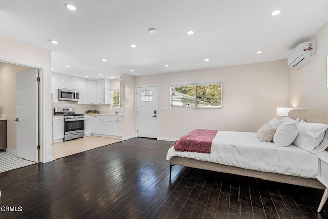 bedroom featuring a sink, baseboards, recessed lighting, light wood finished floors, and an AC wall unit