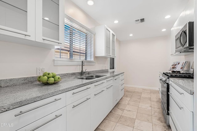 kitchen with white cabinetry, stainless steel appliances, recessed lighting, and a sink