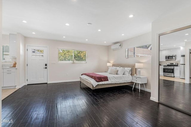 bedroom with a wall mounted air conditioner, hardwood / wood-style flooring, multiple windows, and freestanding refrigerator