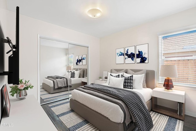 bedroom with wood finished floors and a closet