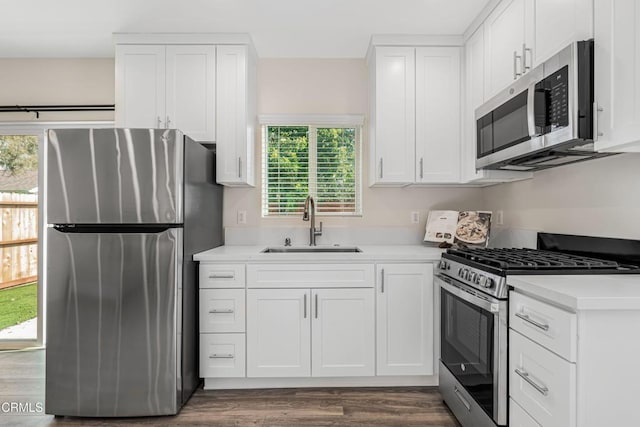 kitchen with white cabinets, appliances with stainless steel finishes, light countertops, and a sink