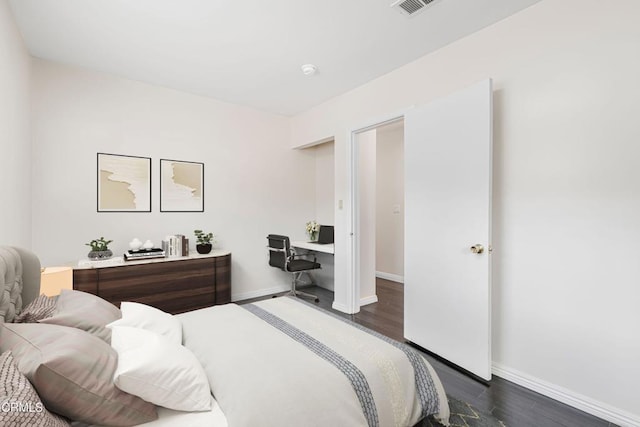 bedroom featuring baseboards, visible vents, and dark wood-type flooring