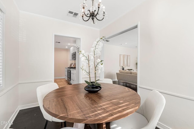 dining space with baseboards, visible vents, ornamental molding, and a notable chandelier
