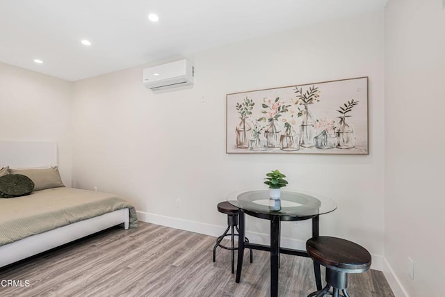 bedroom with recessed lighting, an AC wall unit, wood finished floors, and baseboards