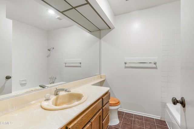 full bathroom with tile patterned flooring, vanity, tiled shower / bath, and toilet