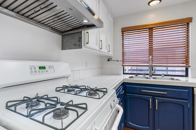 kitchen featuring blue cabinets, sink, wall chimney range hood, white gas range oven, and white cabinets