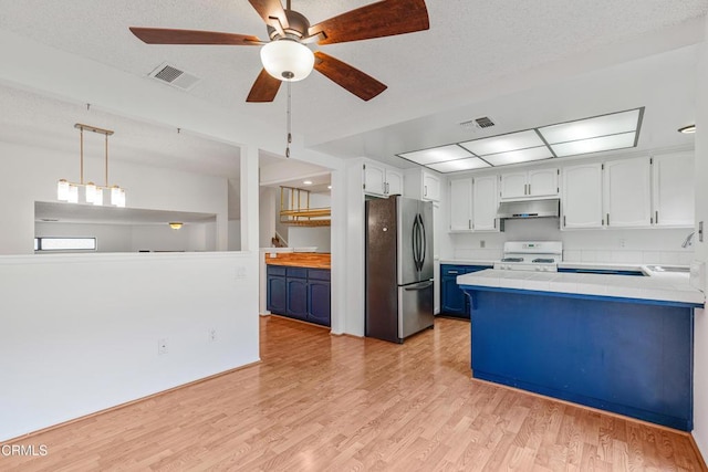 kitchen featuring pendant lighting, blue cabinets, stainless steel fridge, and white range