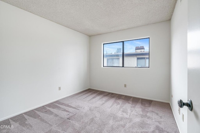 empty room featuring carpet floors and a textured ceiling