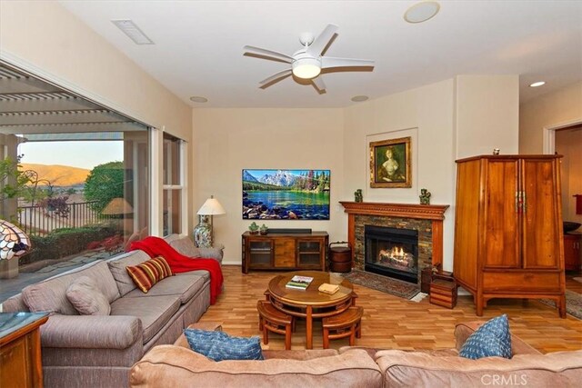 24238 Owl Ct, Corona, CA 92883 - living area with a ceiling fan, a fireplace with flush hearth, light wood-style flooring, visible vents, and recessed lighting