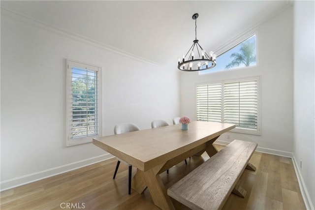 dining room with an inviting chandelier, ornamental molding, and light hardwood / wood-style flooring