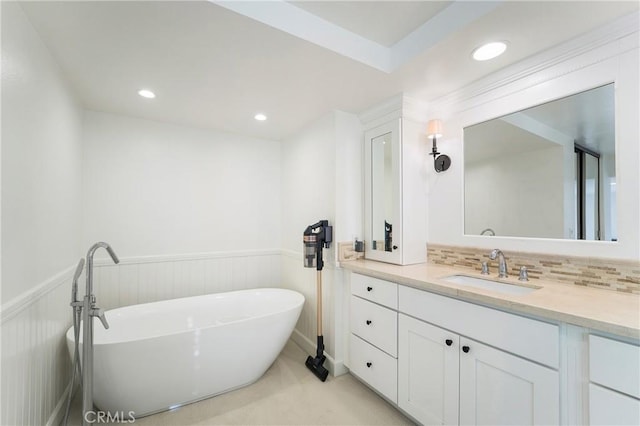 bathroom featuring tasteful backsplash, vanity, and a tub