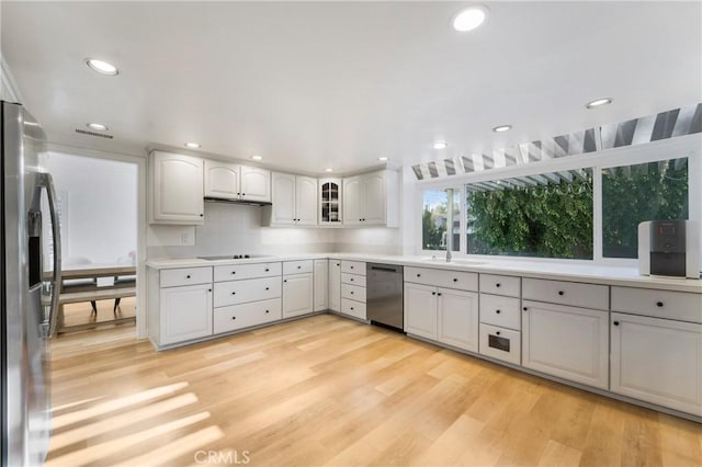 kitchen with white cabinetry, sink, light hardwood / wood-style floors, and appliances with stainless steel finishes