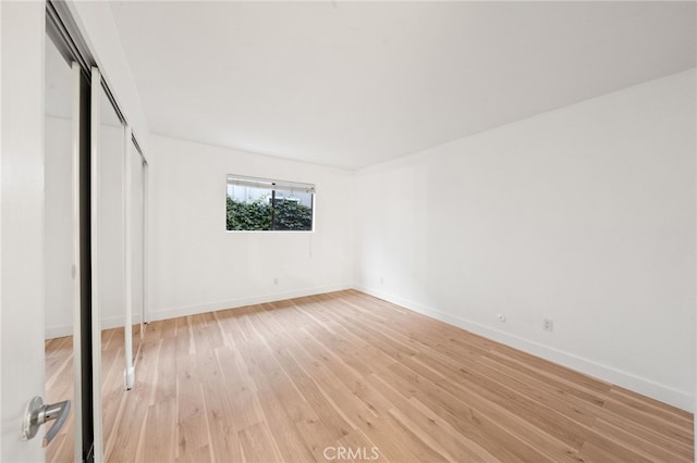 unfurnished bedroom with a closet and light wood-type flooring