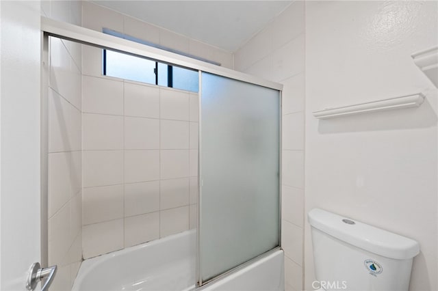 bathroom featuring bath / shower combo with glass door and toilet