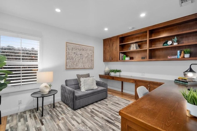 office space featuring built in desk and light hardwood / wood-style floors