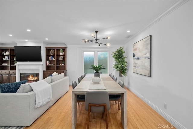 dining space featuring hardwood / wood-style flooring, crown molding, and an inviting chandelier