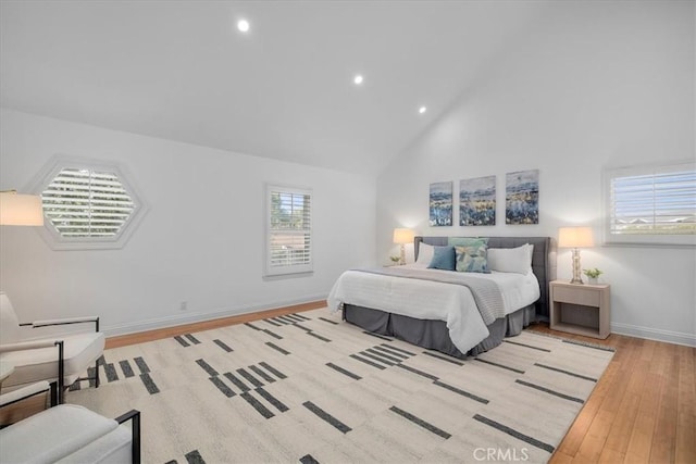 bedroom with high vaulted ceiling and light wood-type flooring