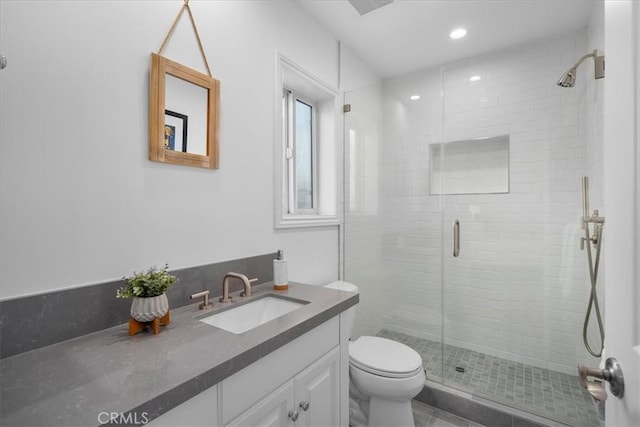 bathroom featuring vanity, toilet, and a shower with shower door