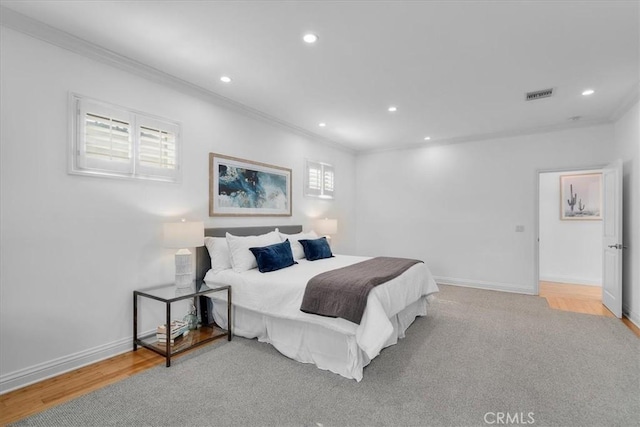 bedroom featuring crown molding and light hardwood / wood-style flooring