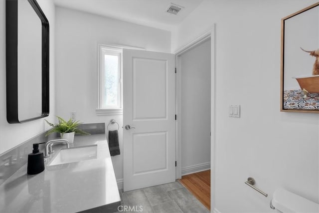 bathroom with vanity, hardwood / wood-style floors, and toilet