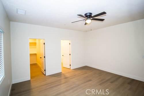 unfurnished bedroom with hardwood / wood-style floors, a spacious closet, and a closet