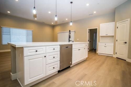 kitchen with a kitchen island, decorative light fixtures, white cabinets, stainless steel dishwasher, and light hardwood / wood-style floors