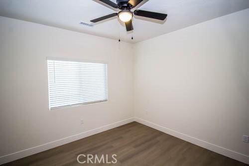 unfurnished room featuring ceiling fan and dark hardwood / wood-style floors