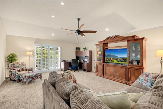 living room with ceiling fan, carpet flooring, and vaulted ceiling