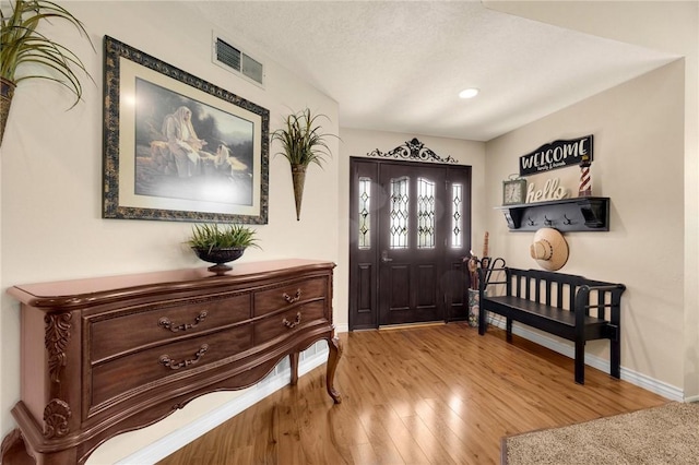 entryway with a textured ceiling and light hardwood / wood-style floors