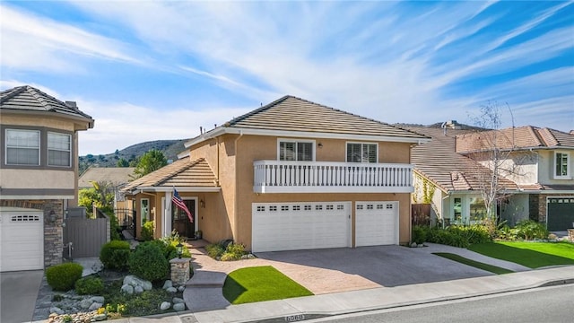 view of front of house with a balcony, a garage, and a mountain view