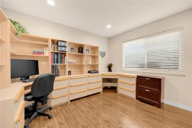 home office with built in desk and light wood-type flooring