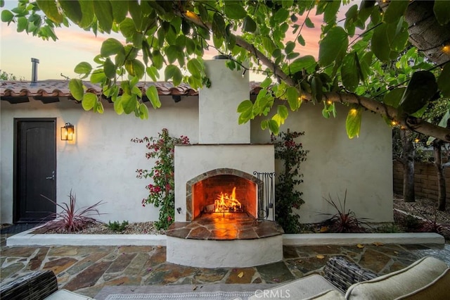 exterior space with a warm lit fireplace