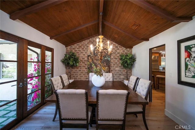 dining area featuring a chandelier, wooden ceiling, lofted ceiling with beams, and wood finished floors