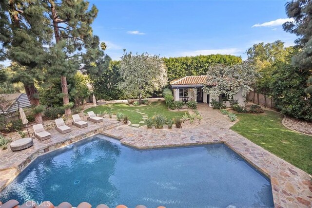 pool with a patio area, a yard, and a fenced backyard