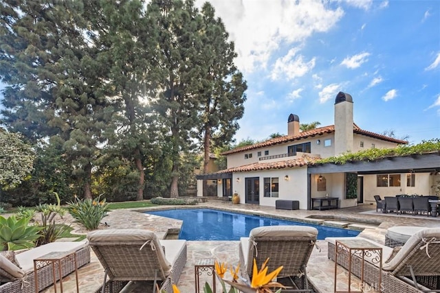 outdoor pool with a patio and an outdoor living space