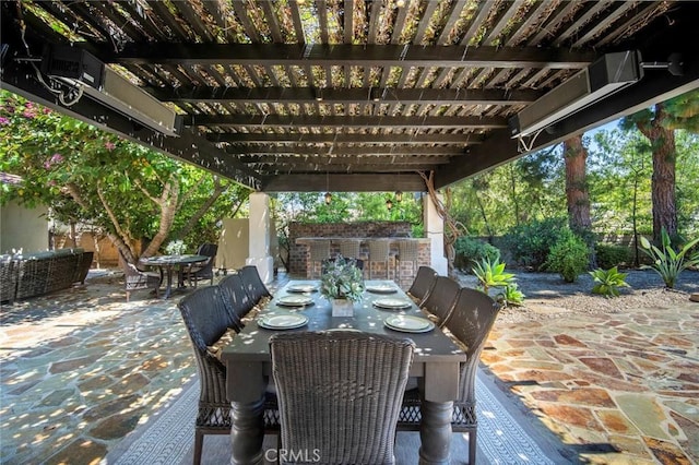 view of patio with outdoor dining space, fence, a pergola, and outdoor dry bar