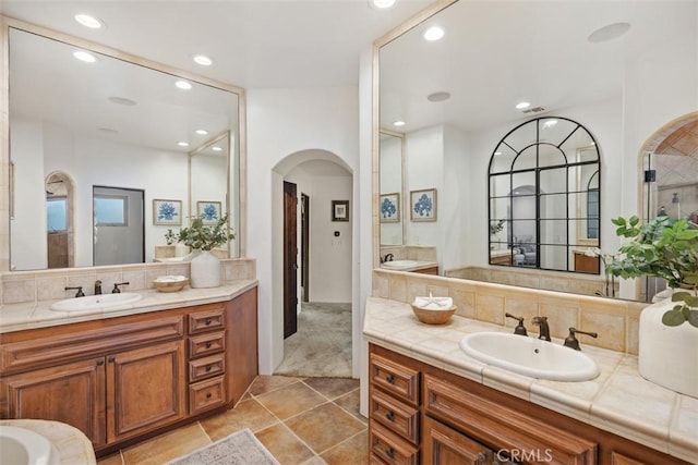 bathroom featuring recessed lighting, backsplash, two vanities, and a sink
