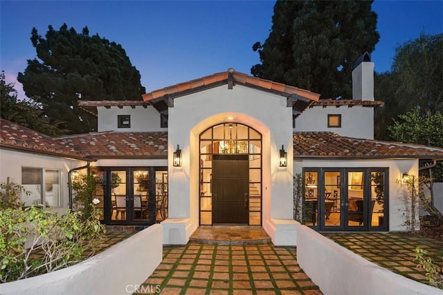 exterior entry at dusk featuring french doors