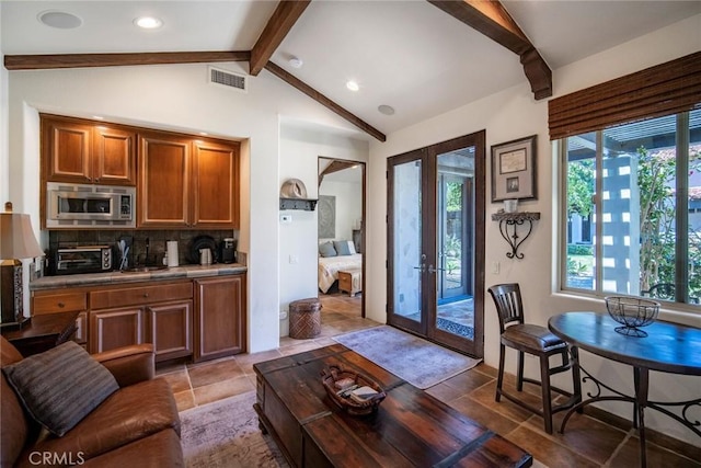 living room with visible vents, a toaster, vaulted ceiling with beams, and french doors