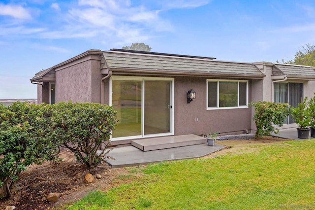 rear view of property featuring a yard