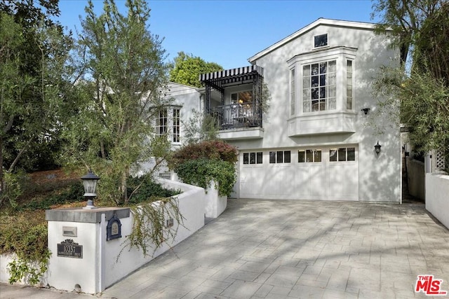 view of front of house featuring a garage and a balcony