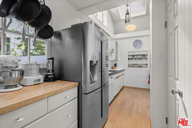 kitchen with white cabinetry, light hardwood / wood-style floors, wood counters, stainless steel fridge with ice dispenser, and decorative light fixtures