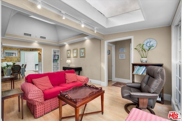 living room with lofted ceiling, track lighting, and light hardwood / wood-style floors