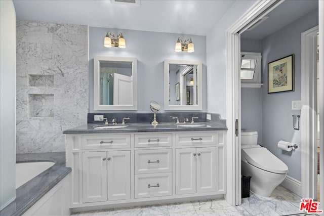 bathroom with vanity, a bath, and toilet