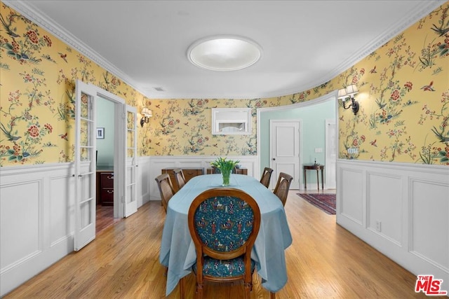 dining area with ornamental molding and light hardwood / wood-style floors