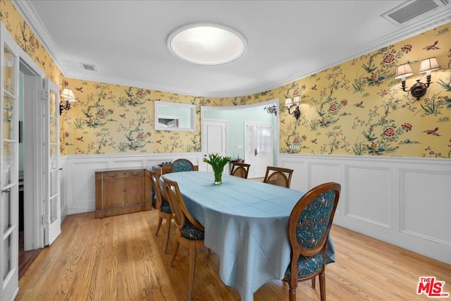 dining area featuring crown molding and light hardwood / wood-style floors