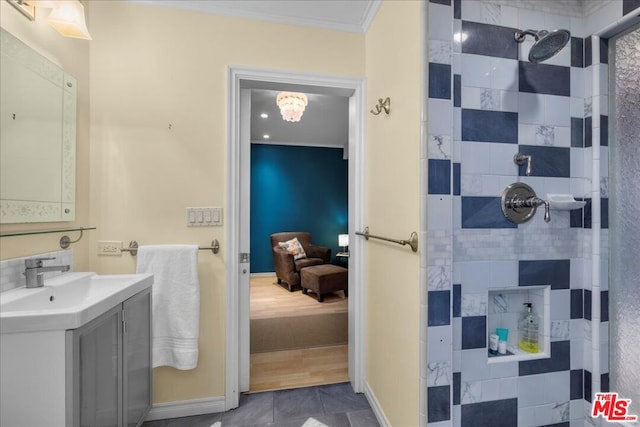 bathroom with crown molding, tiled shower, and vanity