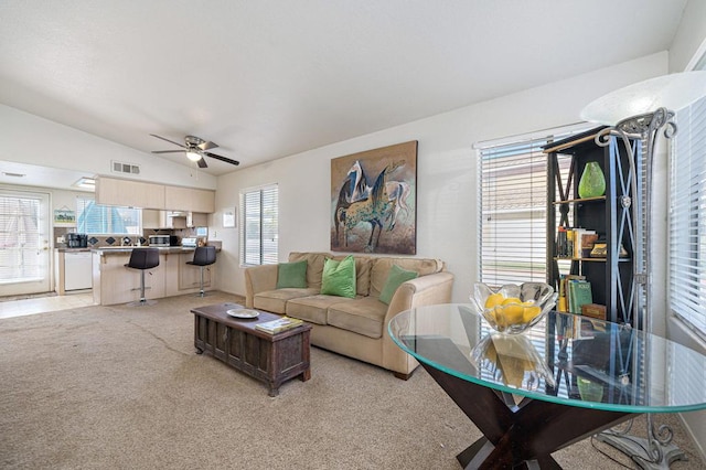 living room featuring ceiling fan, light colored carpet, and vaulted ceiling