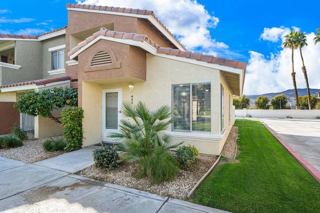 view of front of property with a mountain view and a front lawn