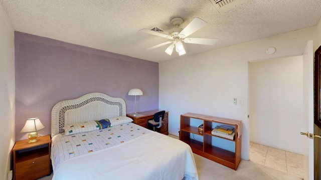 tiled bedroom with ceiling fan and a textured ceiling